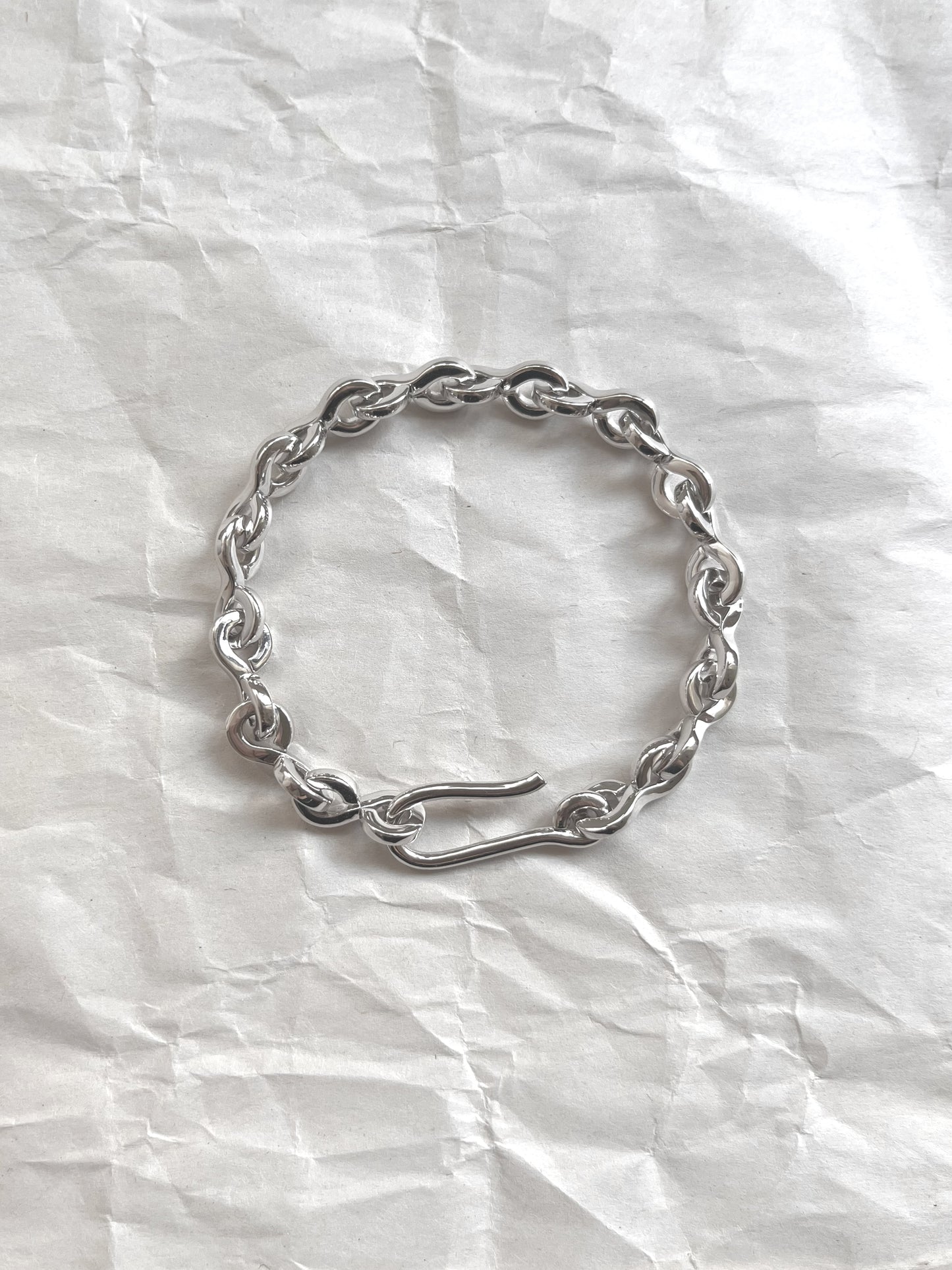 Laura Lombardi Silver Nuova chain bracelet on a white paper background.