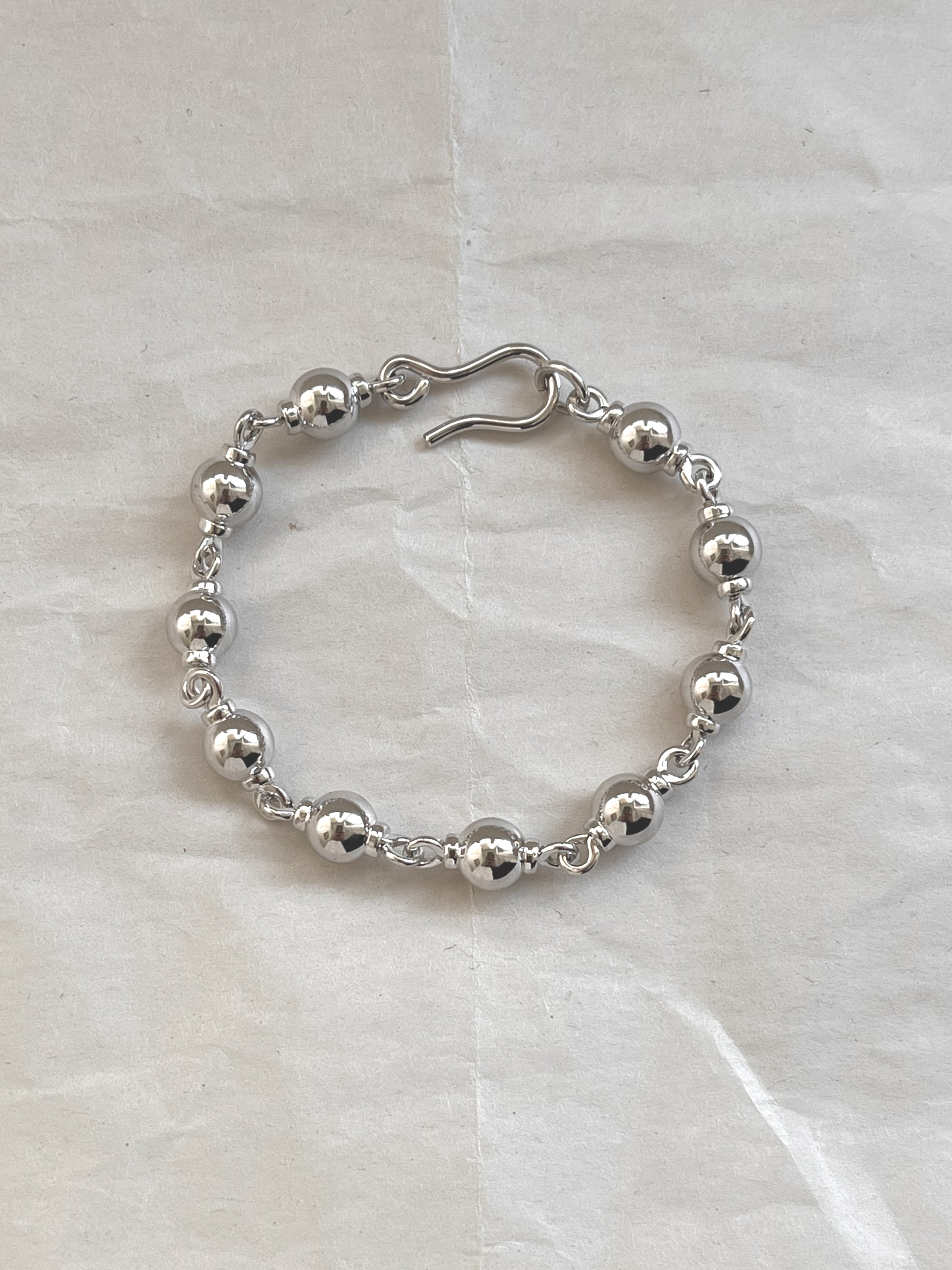 Laura Lombardi Silver Suona beaded bracelet on white paper background.