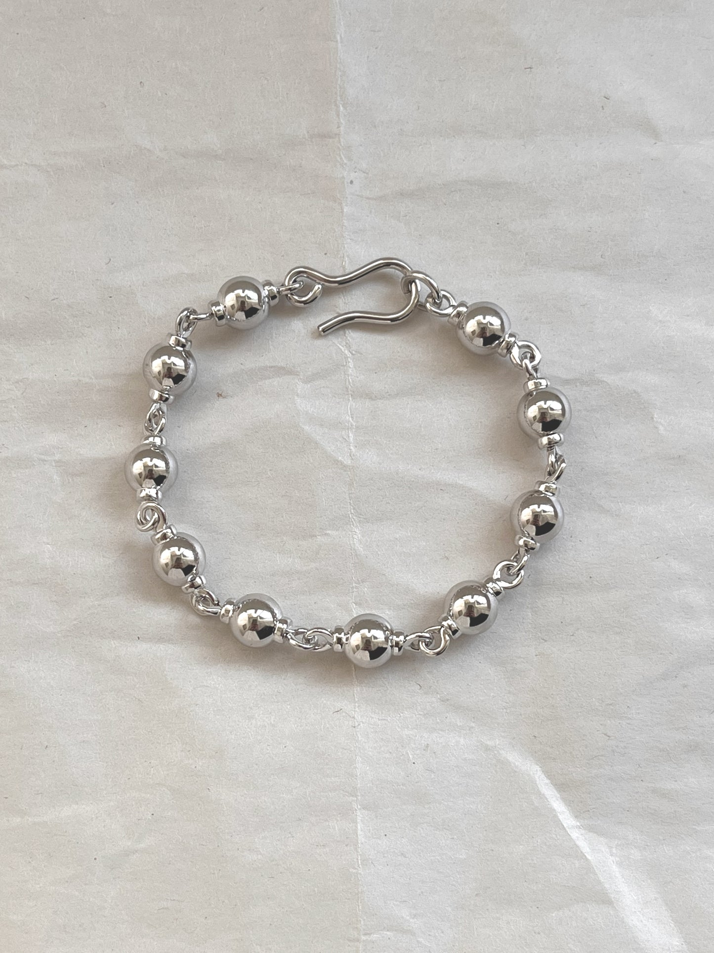 Laura Lombardi Silver Suona beaded bracelet on white paper background.