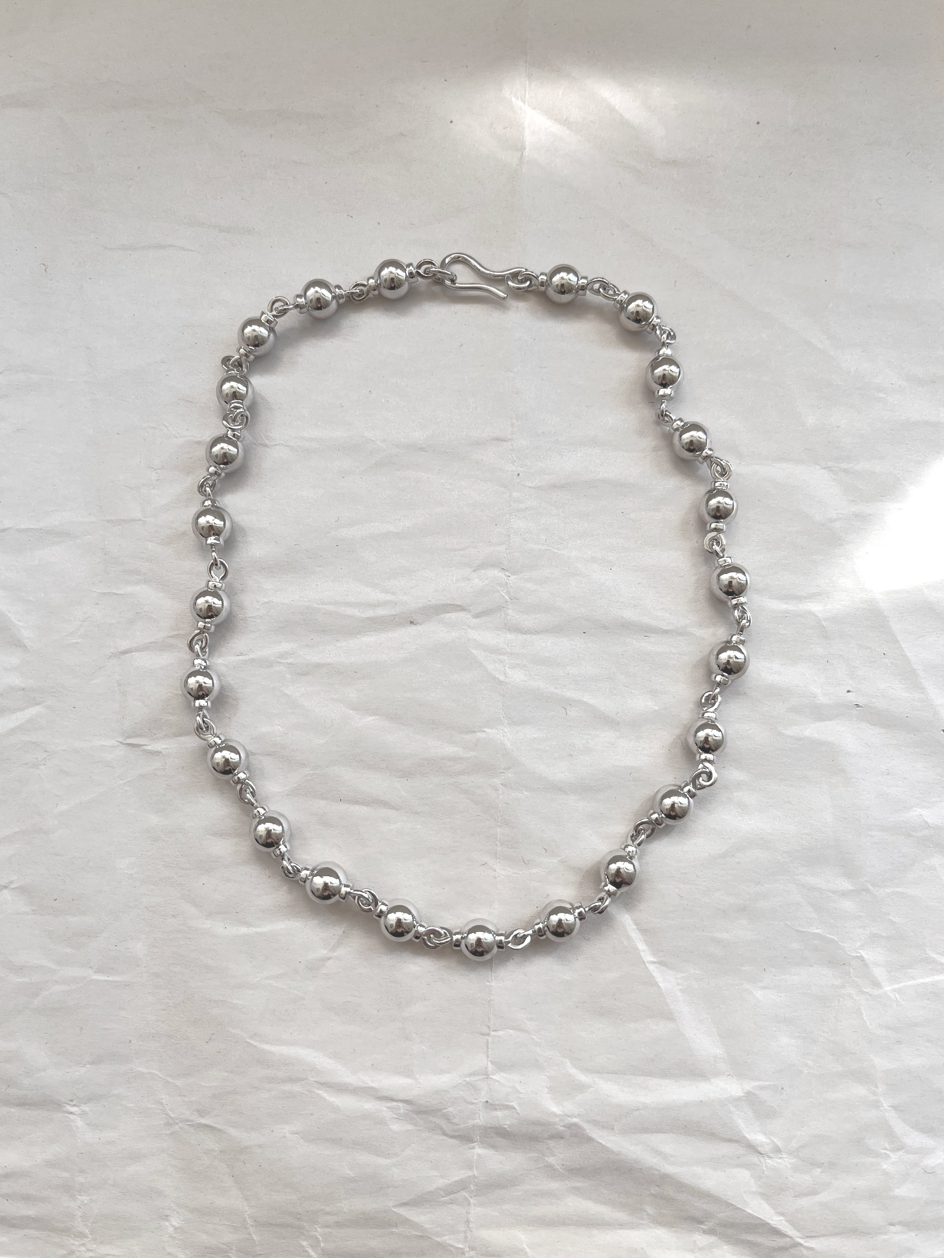 Laura Lombardi Silver Suona beaded necklace on white paper background.