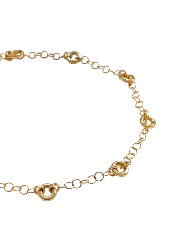 Model wearing the Astra Necklace, a delicate cable chain with circular link accents.