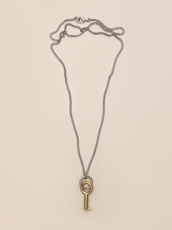 Laura Lombardi Two Tone Entra Necklace, a silver chain necklace featuring a gold key-shaped pendant on a small silver ring, displayed on a neutral background.