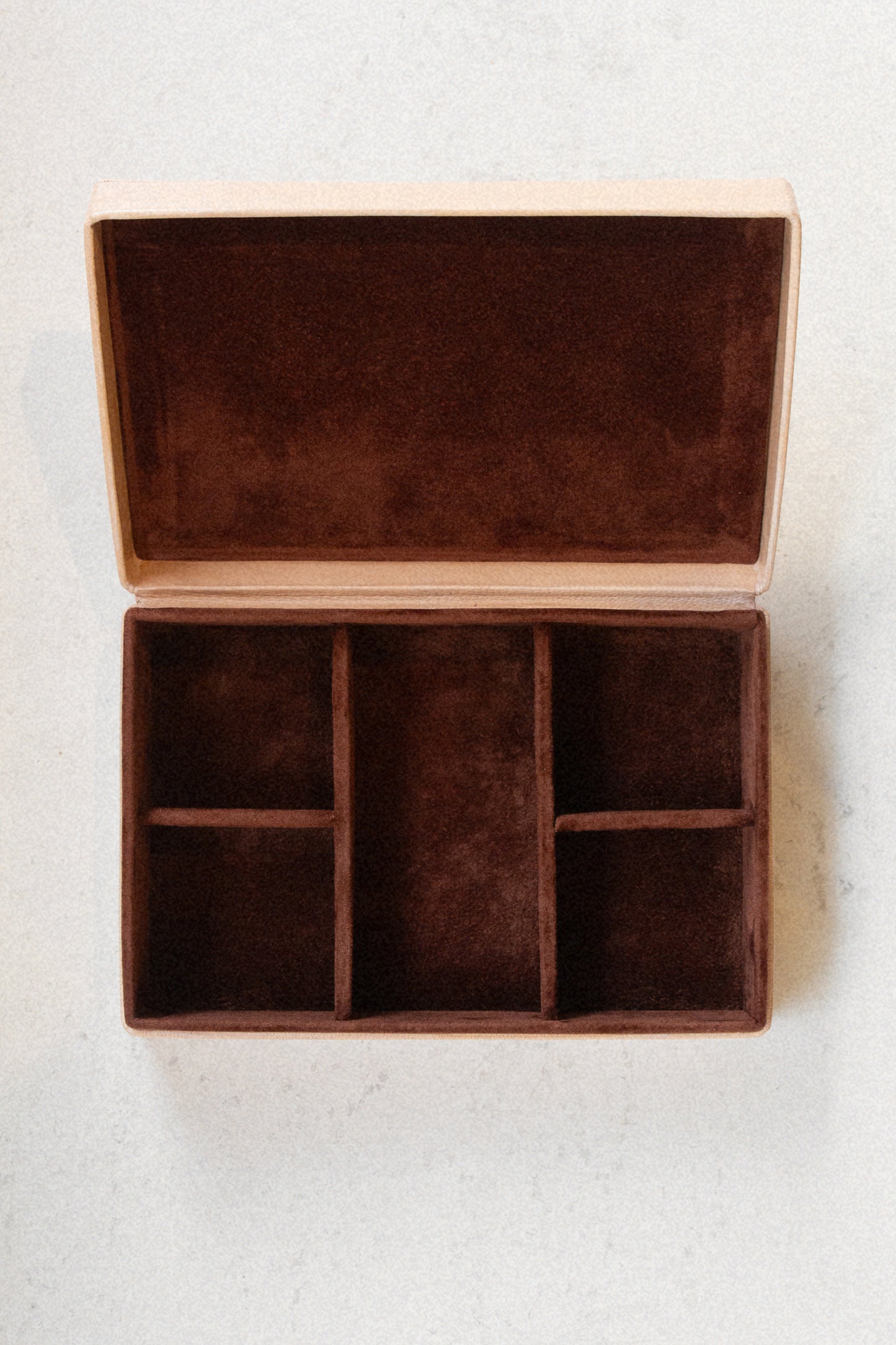 Interior of Laura Lombardi jewelry box, with brown plush lining against a neutral background.