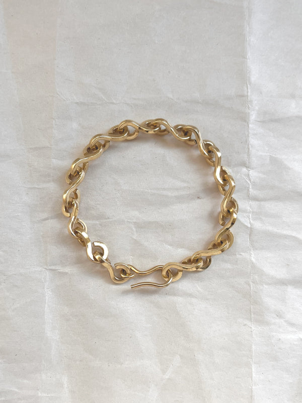 Laura Lombardi gold Nuova chain link bracelet on a white paper background.