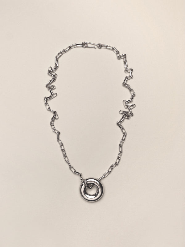 Silver Single Moneta necklace with a round pendant on a silver chain on a neutral colored background