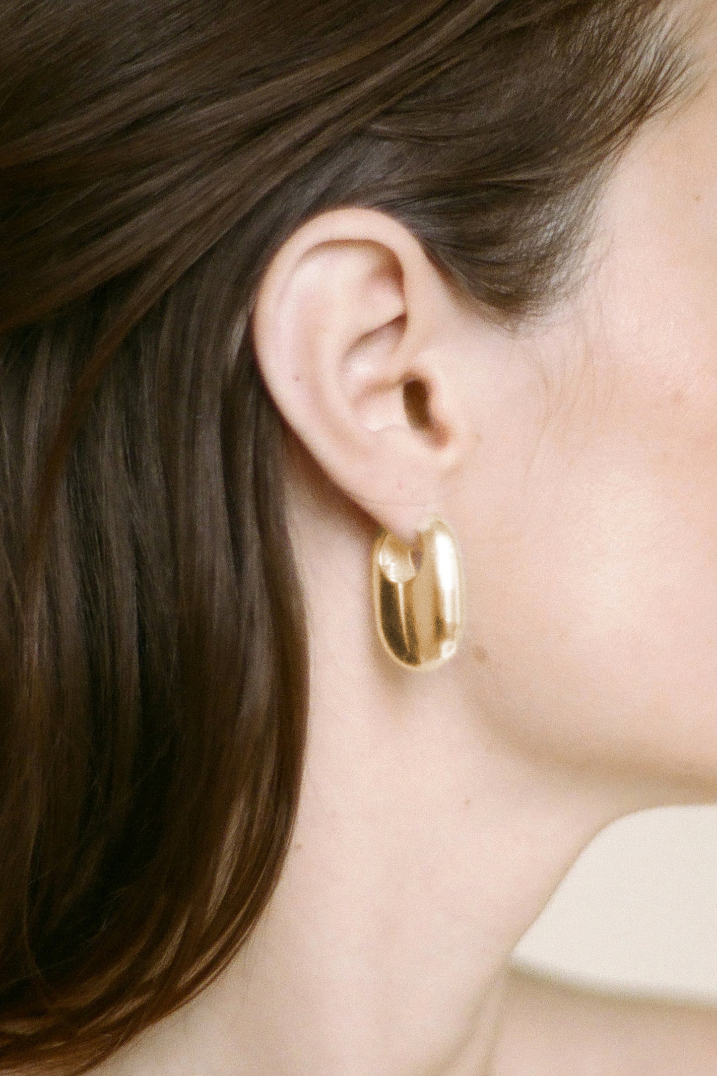 Model wearing Laura Lombardi gold Vola Earrings