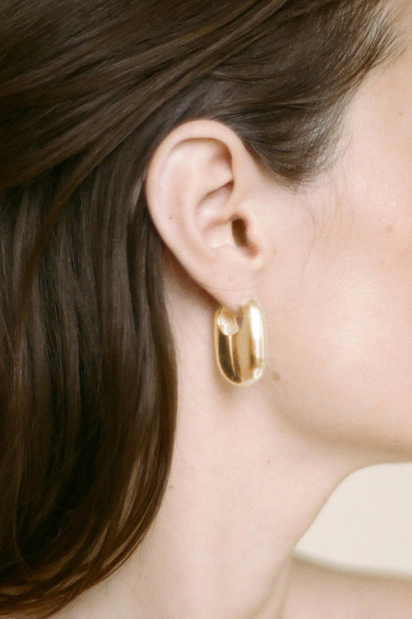 Model wearing Laura Lombardi gold Vola Earrings