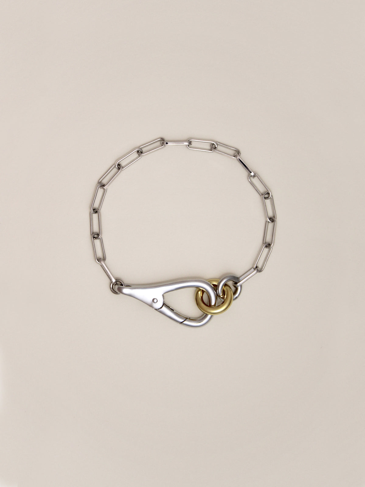 Two Tone Frena Bracelet, a silver-toned chain bracelet with a silver toggle clasp and gold jump ring, displayed on a neutral background.
